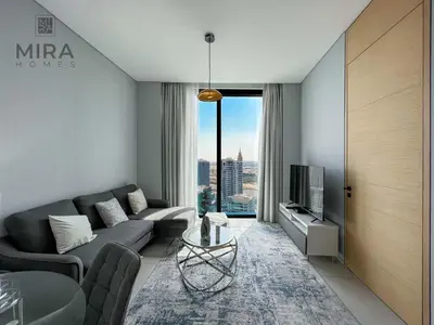 a living room with a couch and a tv at Mira Holiday Homes - Lovely and luxury 1 bedroom in Address JBR in Dubai