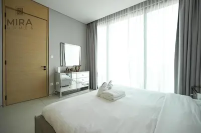 a white bedroom with a large bed and a mirror at Mira Holiday Homes - Lovely and luxury 1 bedroom in Address JBR in Dubai