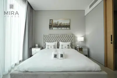a bedroom with a large white bed with two towels at Mira Holiday Homes - Lovely and luxury 1 bedroom in Address JBR in Dubai