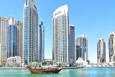 a boat in the water in front of a city at Frank Porter - Time Place Tower in Dubai