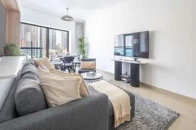 a living room with a couch and a tv at Frank Porter - Time Place Tower in Dubai