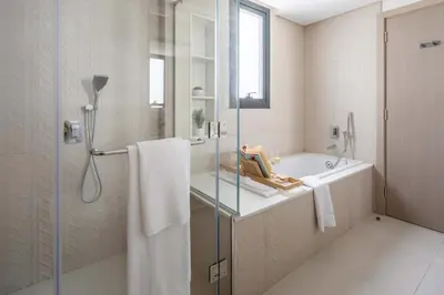 a bathroom with a shower and a sink and a tub at Frank Porter - Murooj Al Furjan West in Dubai