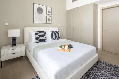 a bedroom with a white bed with a tray on it at Frank Porter - Murooj Al Furjan West in Dubai