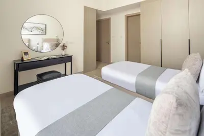 a hotel room with two beds and a mirror at Frank Porter - Murooj Al Furjan West in Dubai