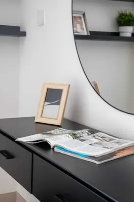 a black desk with a mirror and a magazine at Frank Porter - Murooj Al Furjan West in Dubai