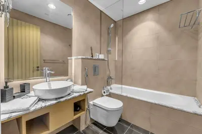 a bathroom with a sink and a toilet and a tub at Panoramic Burj Views, Famous Infinity Pool, Balcony Mini Golf - Paramount Midtown in Dubai
