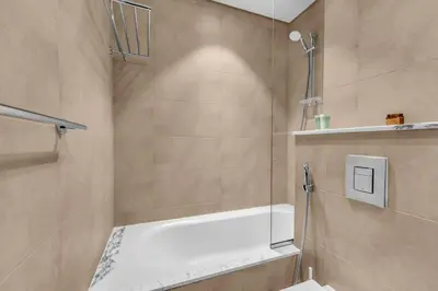 a bathroom with a shower and a toilet in it at Panoramic Burj Views, Famous Infinity Pool, Balcony Mini Golf - Paramount Midtown in Dubai