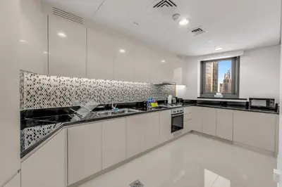 a large kitchen with white cabinets and a window at Panoramic Burj Views, Famous Infinity Pool, Balcony Mini Golf - Paramount Midtown in Dubai