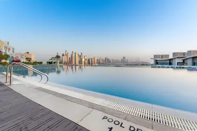 a swimming pool with a city in the background at Luxury Palm Studio, Rooftop Infinity Pool, Beach Access in Dubai
