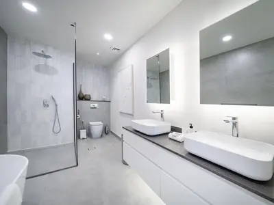 a white bathroom with two sinks and a shower at Stunning 2-Bedroom Duplex in Dubai Marina in Dubai