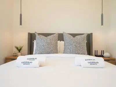 a white bed with two pillows on top of it at Stunning 2-Bedroom Duplex in Dubai Marina in Dubai