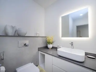 a bathroom with a white sink and a mirror at Stunning 2-Bedroom Duplex in Dubai Marina in Dubai