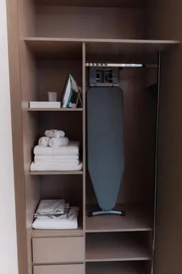 a closet with a shelf with towels and a desk at Luxury Apt Infinity Pool with Burj View in Dubai
