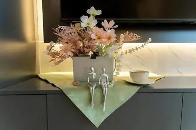 a table with a bucket of flowers and a cup of coffee at Luxury Apt Infinity Pool with Burj View in Dubai