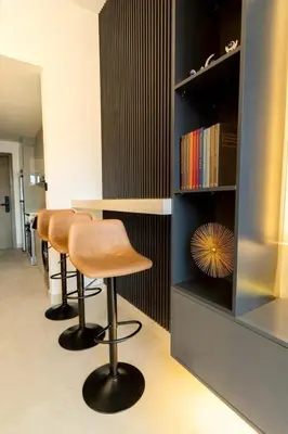 a bar with a row of stools and a book shelf at Luxury Apt Infinity Pool with Burj View in Dubai