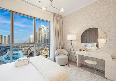 a bedroom with a bed and a large window at Livin' Holidays - 2 BR - Burj Khalifa & Fountain in Dubai