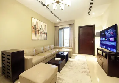 a living room with a couch and a flat screen tv at Stunning 1BR on a High Floor in Dubai Downtown in Dubai