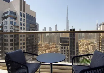 a table and chairs on a balcony with a view of a city at Stunning 1BR on a High Floor in Dubai Downtown in Dubai