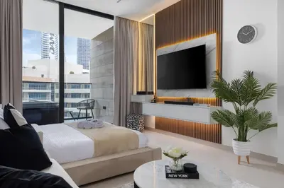 a bedroom with a bed and a tv and a couch at Waves - Luxe Studio with Jacuzzi & City Views in Dubai