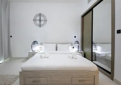 a bedroom with a large white bed with two lamps at Elegant Studio in Binghatti Canal, Downtown Access in Dubai