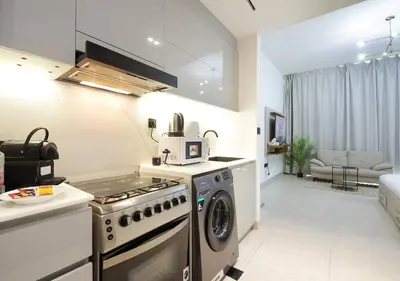 a kitchen with a stove and a washing machine at Elegant Studio in Binghatti Canal, Downtown Access in Dubai