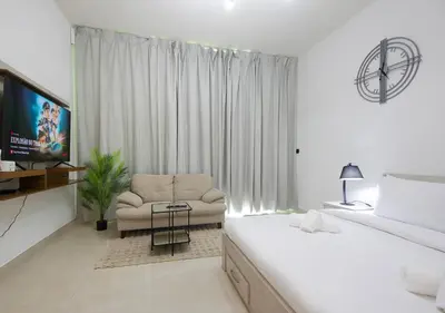 a bedroom with a bed and a chair and a television at Elegant Studio in Binghatti Canal, Downtown Access in Dubai