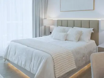 a white bed with white sheets and pillows in a bedroom at Luxury Furnished, Brand New in Dubai