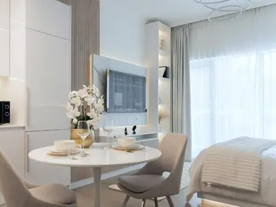 a white room with a table and chairs and a bed at Luxury Furnished, Brand New in Dubai