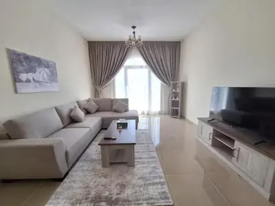a living room with a couch and a flat screen tv at Ayla Residence 1 in Dubai