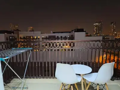 two chairs and a table on a balcony at night at Ayla Residence 1 in Dubai