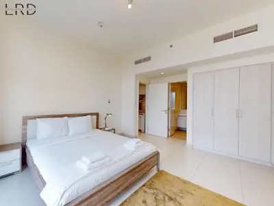 a white bedroom with a large bed and white cabinets at Chic 2 Bedroom Apartment - Park Point - Dubai Hills in Dubai