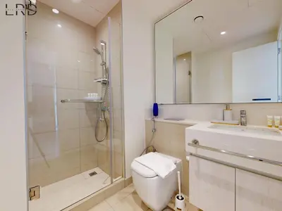 a bathroom with a shower and a toilet and a sink at Chic 2 Bedroom Apartment - Park Point - Dubai Hills in Dubai