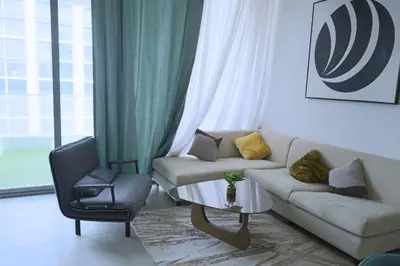a living room with a couch and a chair at Cozy 1BR Apt in Bluebell Residences,JVC in Dubai