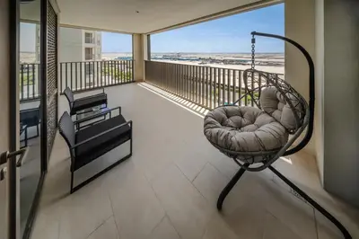 a balcony with a swing and a chair at Bright and Stylish 2BD at Creek Beach, Sleeps 4 in Dubai