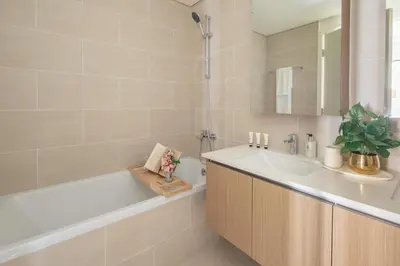 a white bathroom with a tub and a sink at Frank Porter - Groove 1 at Creek Beach in Dubai