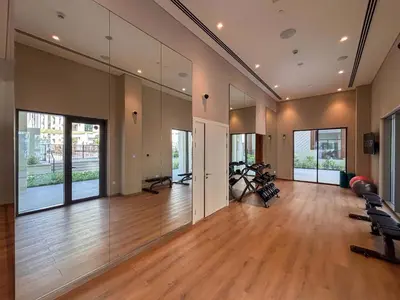 a gym with treadmills and exercise bikes in a room with mirrors at Frank Porter - Groove 1 at Creek Beach in Dubai