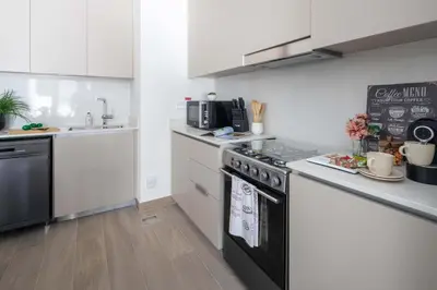 a kitchen with white cabinets and a black stove top oven at Frank Porter - Groove 1 at Creek Beach in Dubai