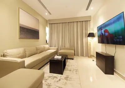 a living room with a couch and a flat screen tv at 2BR Stylish Elite Apartment Near Burj Khalifa in Dubai