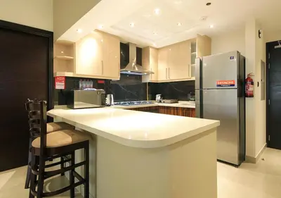 a kitchen with a refrigerator and a counter top at 2BR Stylish Elite Apartment Near Burj Khalifa in Dubai