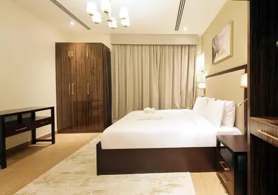 a bedroom with a large white bed and a cabinet at 2BR Stylish Elite Apartment Near Burj Khalifa in Dubai