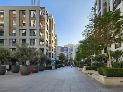 a sidewalk in a city with trees and buildings at Luxury Apt and Private Beach with cooled sand in Dubai