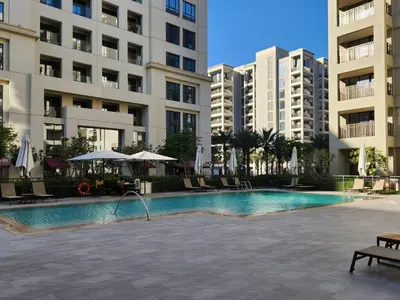 a swimming pool in front of some apartment buildings at Luxury Apt and Private Beach with cooled sand in Dubai