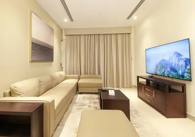 a living room with a couch and a flat screen tv at Modern 2BR Apartment Near Dubai Mall with Pool Gym in Dubai