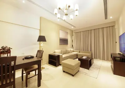 a living room with a couch and a table and a desk at Modern 2BR Apartment Near Dubai Mall with Pool Gym in Dubai