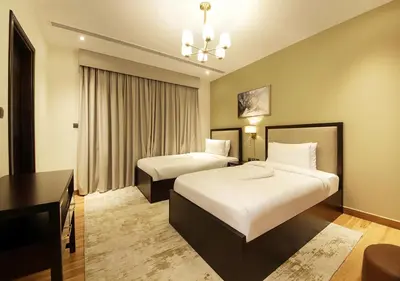 a hotel room with two beds and a desk at Modern 2BR Apartment Near Dubai Mall with Pool Gym in Dubai