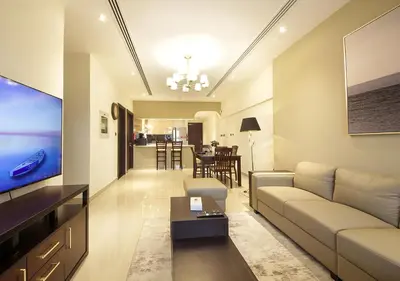 a living room with a couch and a tv at Modern 2BR Apartment Near Dubai Mall with Pool Gym in Dubai
