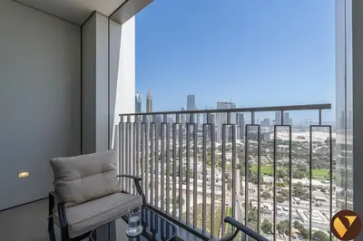 a chair on a balcony with a view of a city at Vogue Downtown Views II with Direct Access to Dubai Mall Via a Climate Controlled Bridge, One Bedroom Apartment with Balcony and City View in Dubai