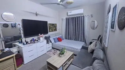 a living room with a couch and a flat screen tv at Holidays home in Dubai
