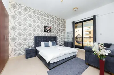 a bedroom with a bed and a couch at Holidays home in Dubai
