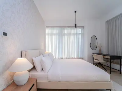 a white bedroom with a white bed and a desk at Burj Views 3 min from Dubai Mall Luxury DownTown Residence in Dubai
